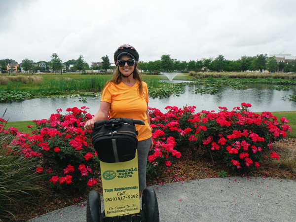 Karen Duquette on a Segway, flowers amd a pond